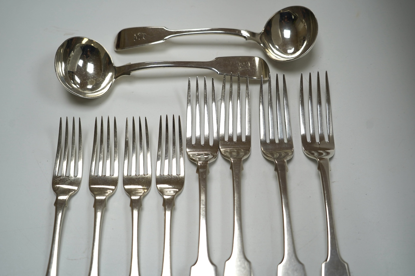 A pair of William IV silver fiddle pattern sauce ladles, William Eaton, London, 1834, 18.1cm, a set of four Victorian silver fiddle pattern table forks, Exeter, 1838 and a set of four George III silver dessert forks, Lon